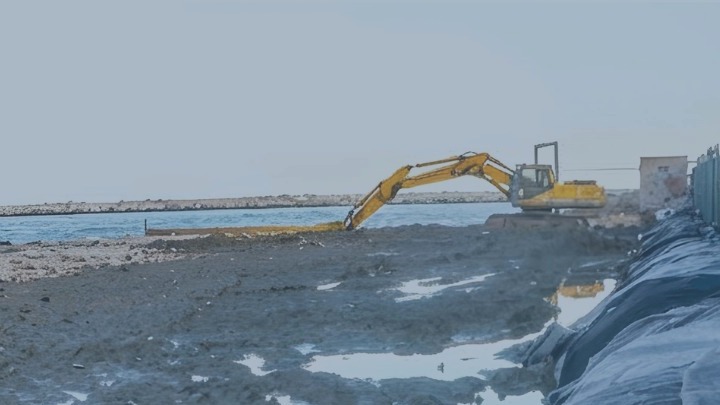 Escavatore al lavoro sulla costa interessata dal progetto